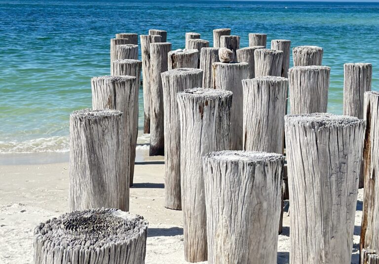 Florida Strand mit Blick auf einen alten zerstörten Steg unter blauen Himmel