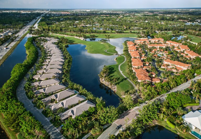 Blick auf eine Wohnanlage mit Golfplatz in Cape Coral Florida unter blauen Himmel.